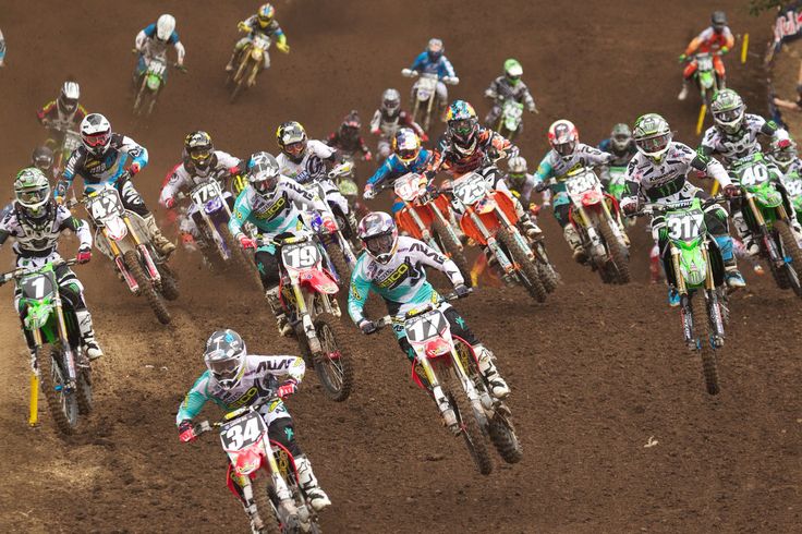 Piloti in gara durante una competizione di motocross su pista sterrata