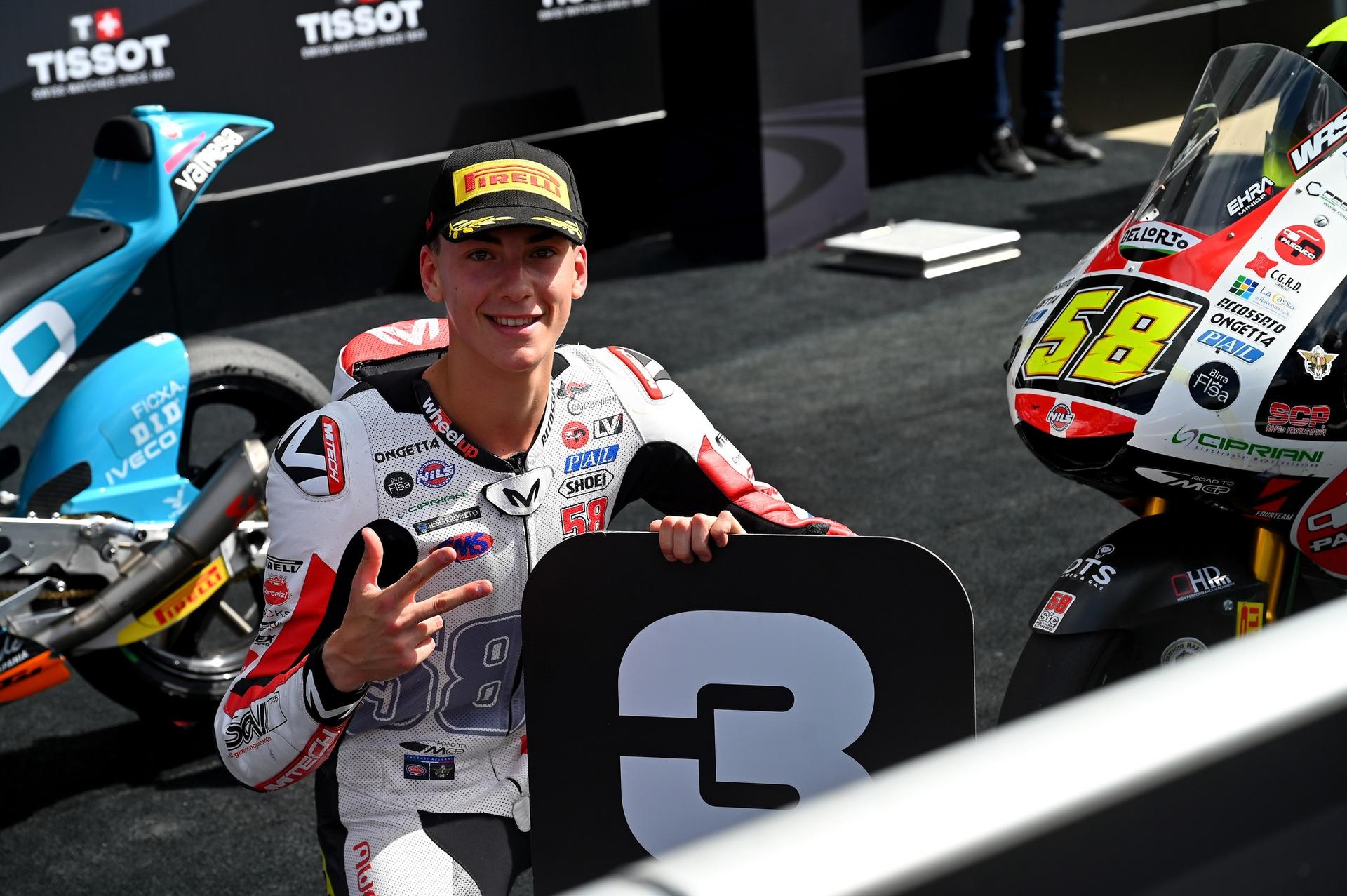 Luca Lunetta posa con il cartello del terzo posto accanto alla sua moto numero 58