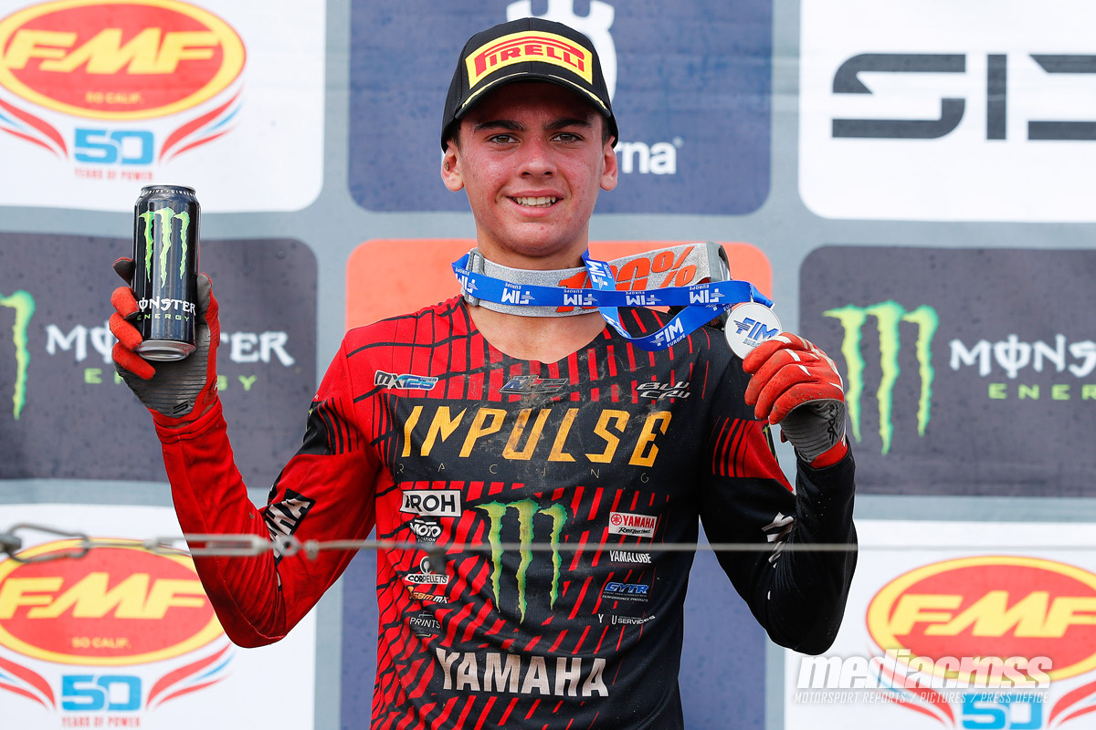 Faure festeggia il secondo posto al GP Motocross 2025 con medaglia FIM e lattina Monster Energy.