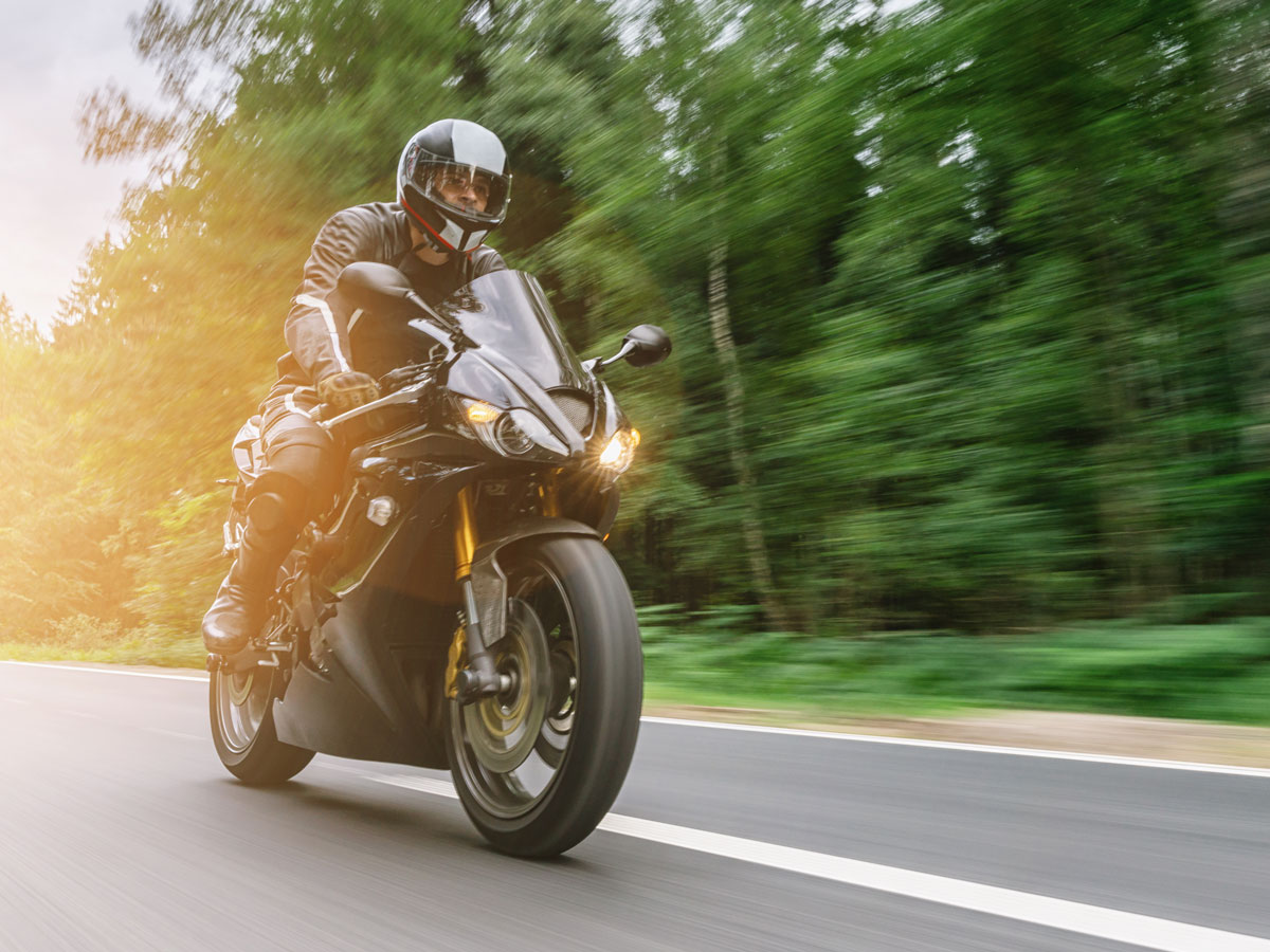 Pilota che sfreccia con moto da strada